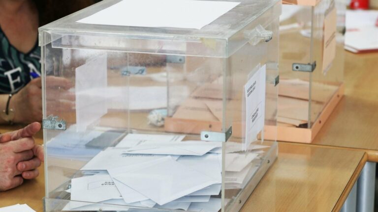 Urna y papeletas en una mesa electoral